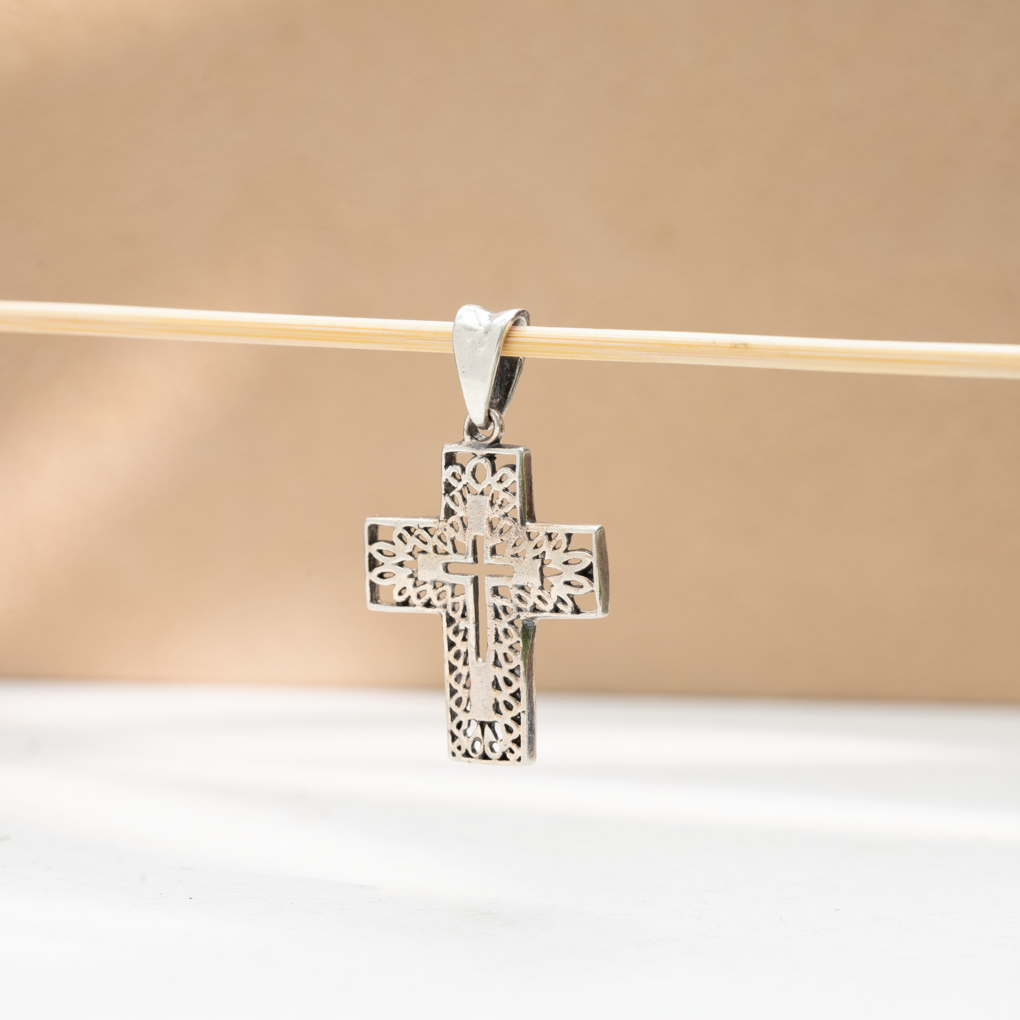 Intricate cutwork silver cross pendant