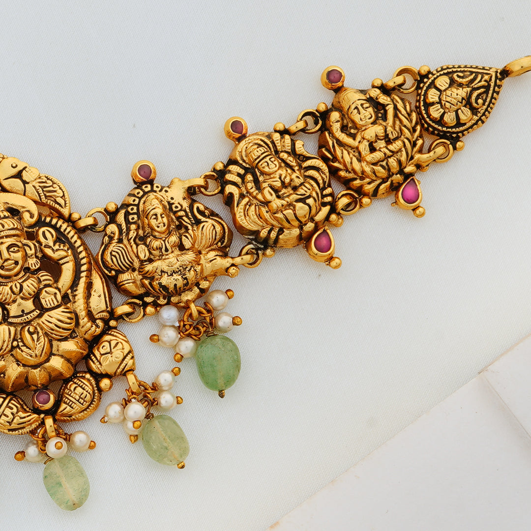 Intricately carved Lakshmi choker with antique finish and pearl-green drops in gold-plated silver