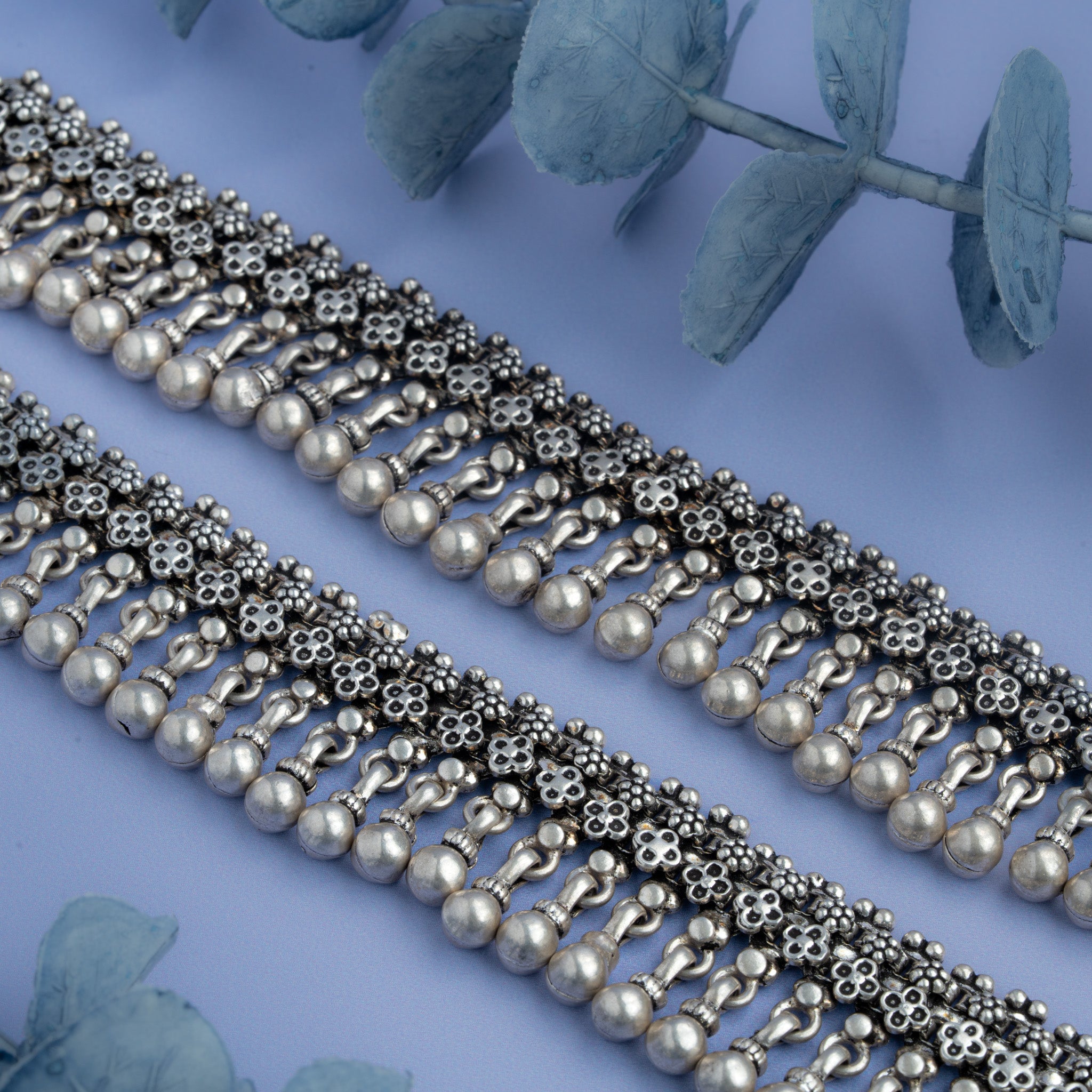 Oxidized silver anklet with floral motifs and dangling ghungroo beads