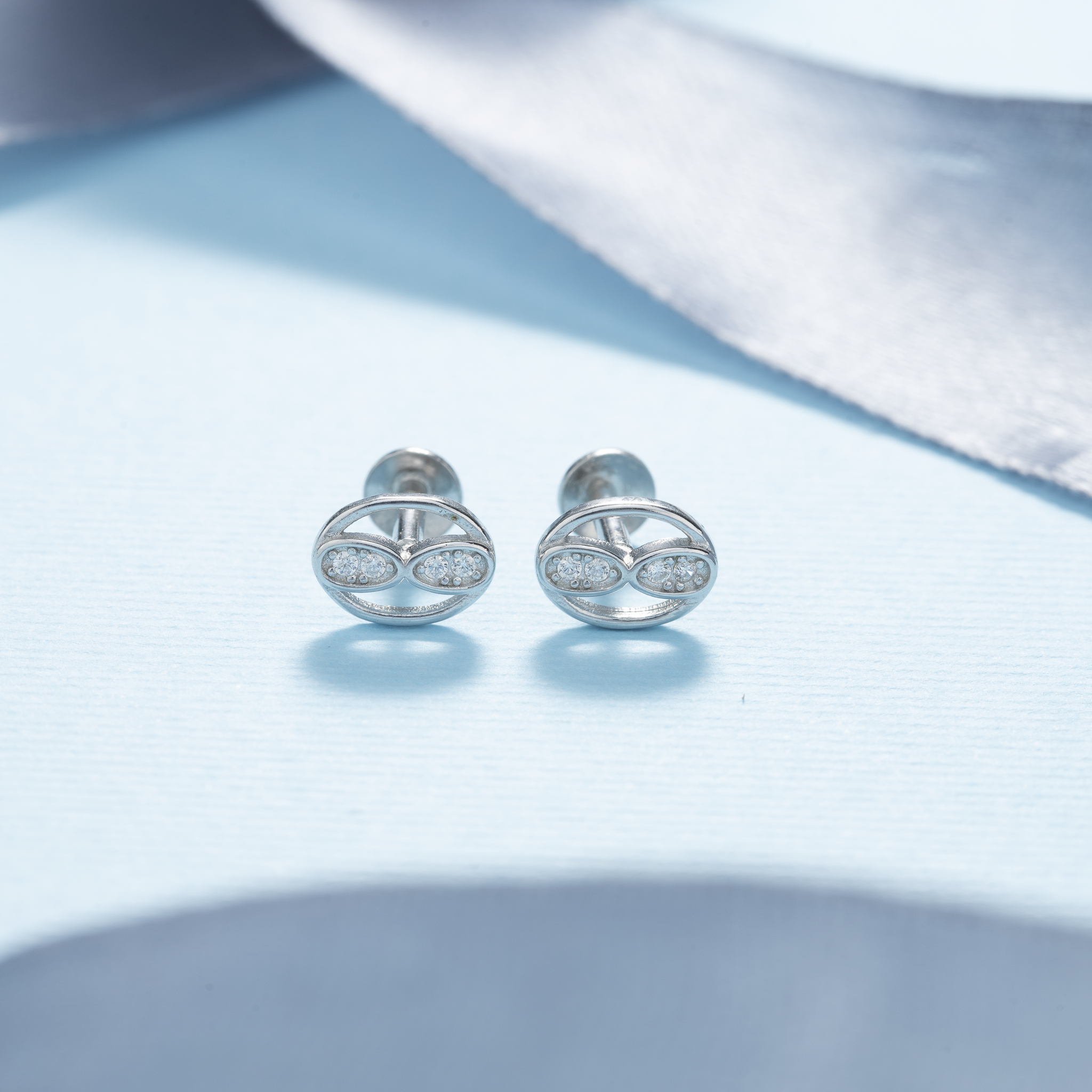 Round silver stud earrings with infinity design