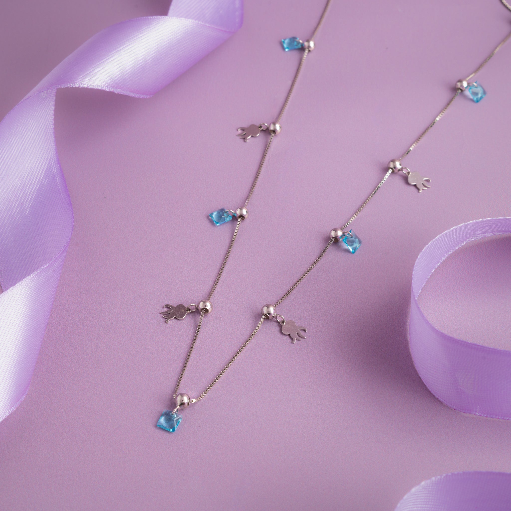 Silver charm necklace with blue crystal drops