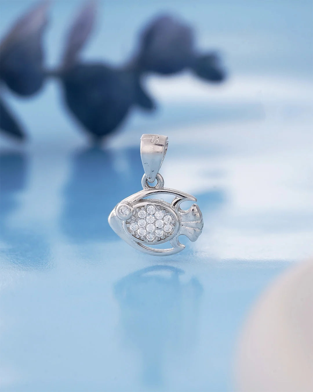 Silver fish-shaped pendant with stones