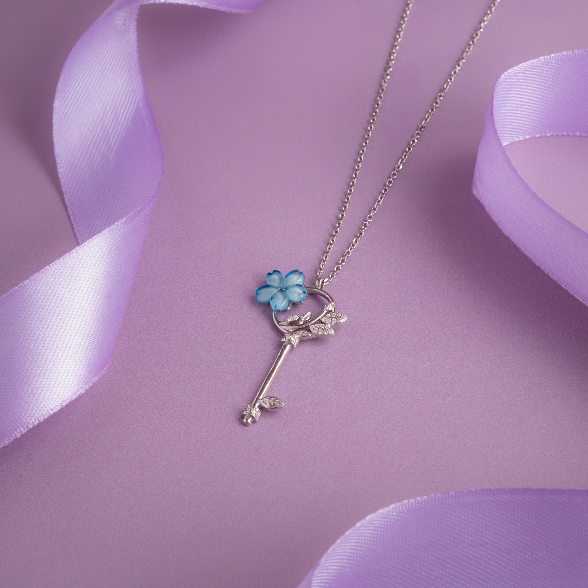 Silver key pendant necklace with blue floral enamel