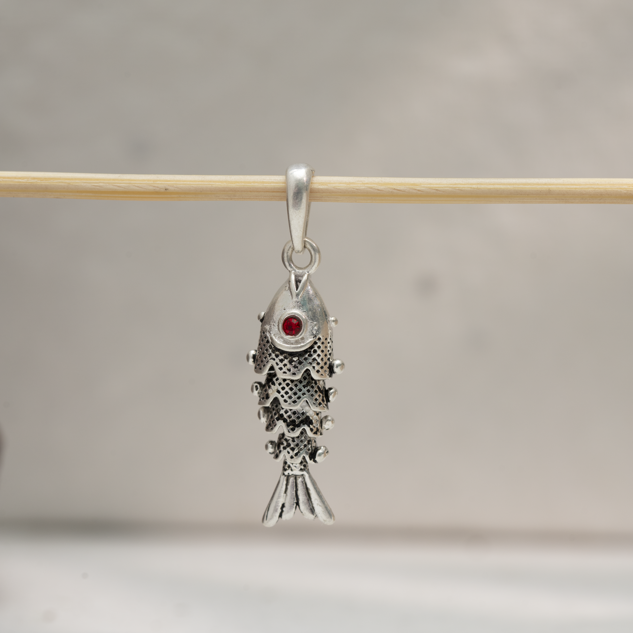 Sterling silver fish pendant with red stone