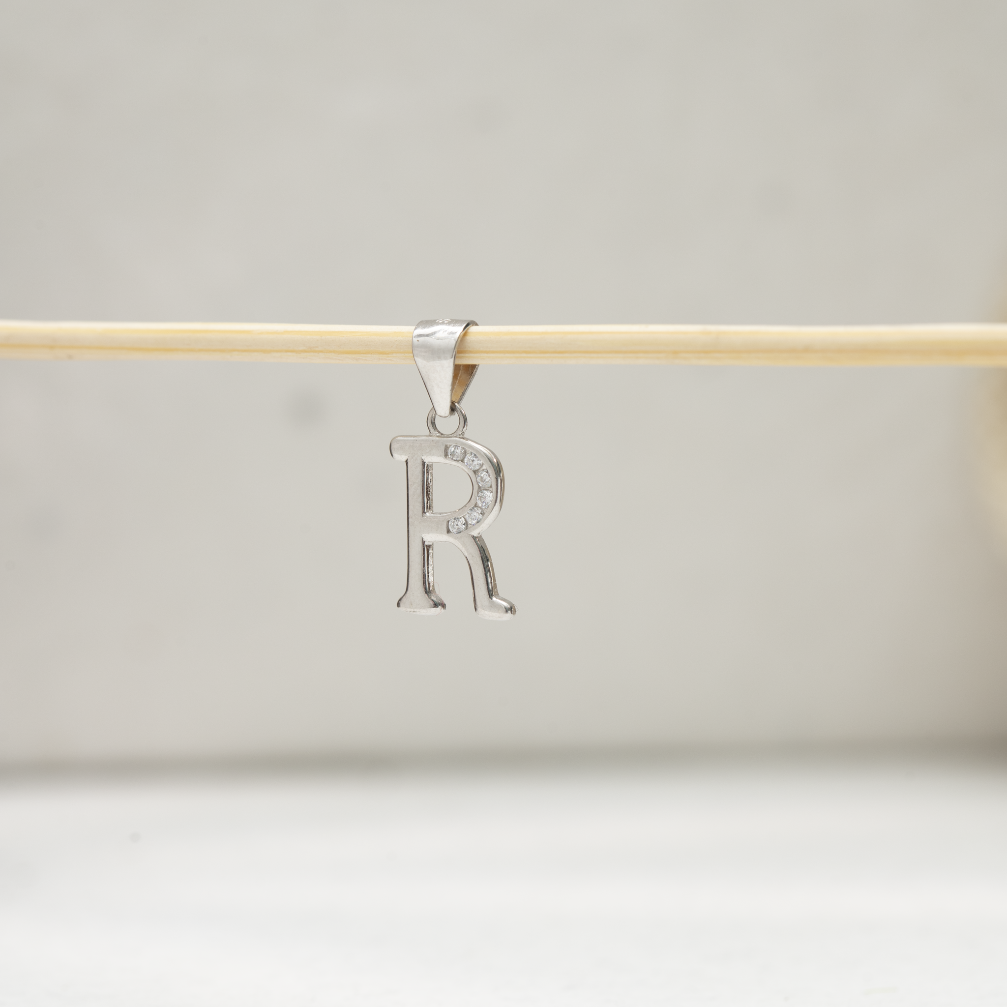 Stone studded alphabet R silver pendant
