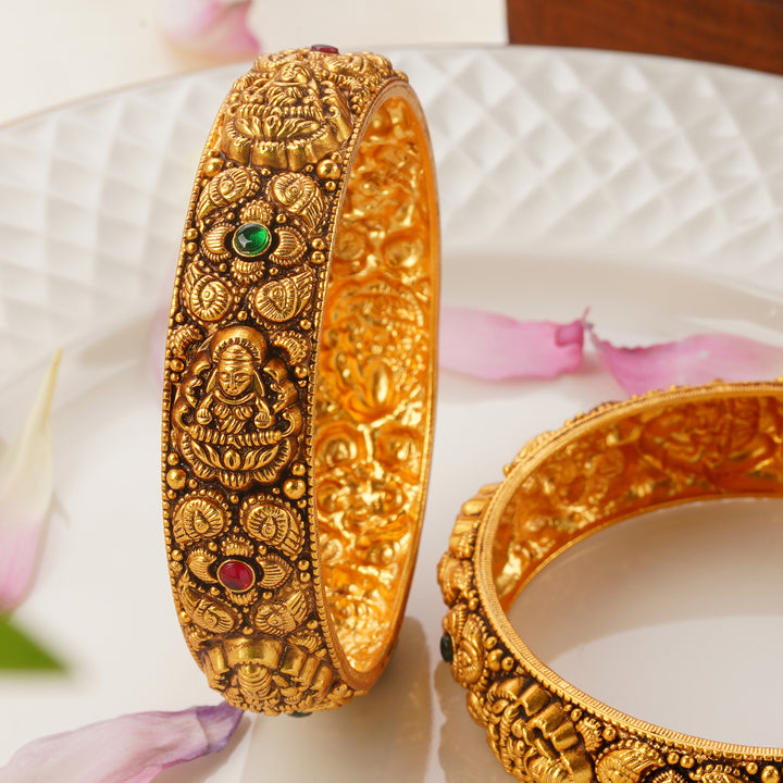 Traditional antique gold bangles with Lakshmi motifs and gemstone work