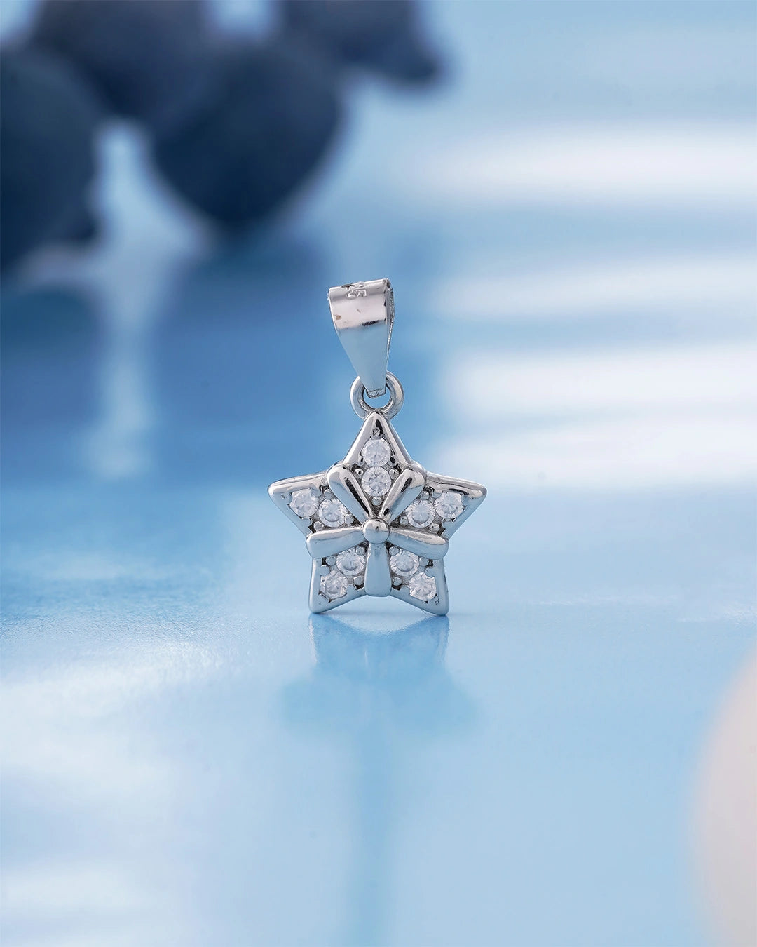 silver star-shaped pendant with clear gemstones